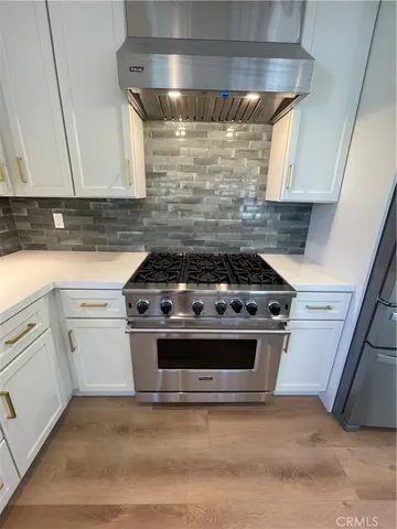 a kitchen with a refrigerator and a stove top oven