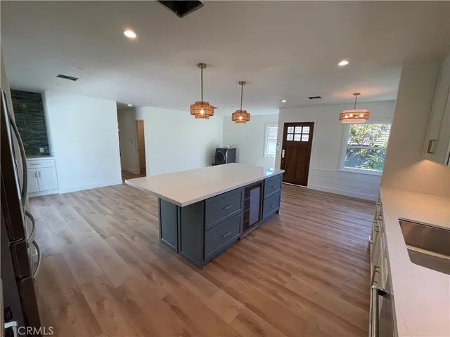 an empty room with wooden floor exposed radiator and windows