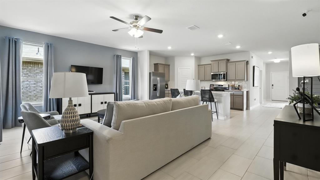 304 Perk Street Keene, TX 76059 - Photo 10 of 34 a living room with furniture a dining table and a flat screen tv