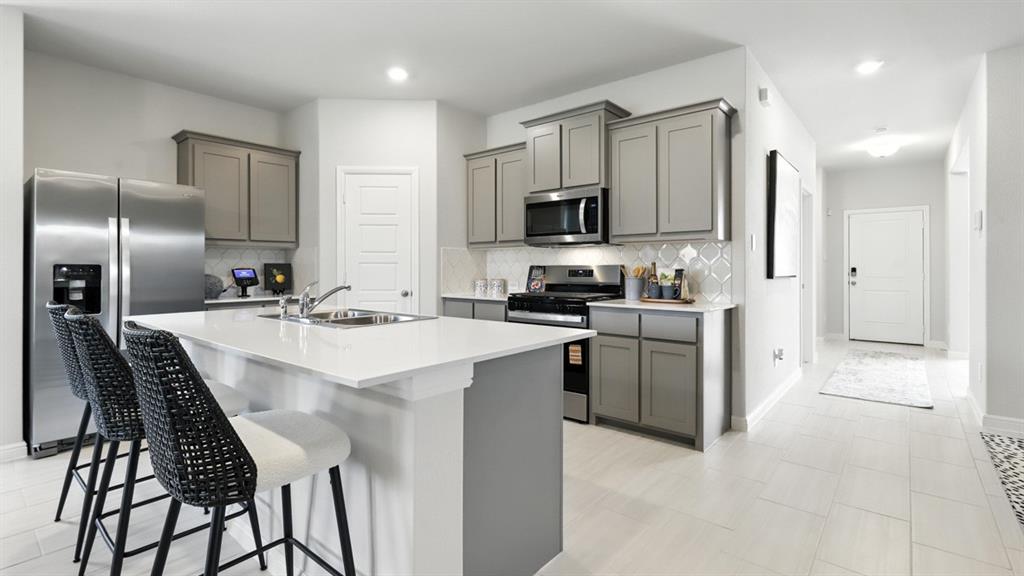 304 Perk Street Keene, TX 76059 - Photo 32 of 34 a kitchen with stainless steel appliances kitchen island a refrigerator sink and microwave