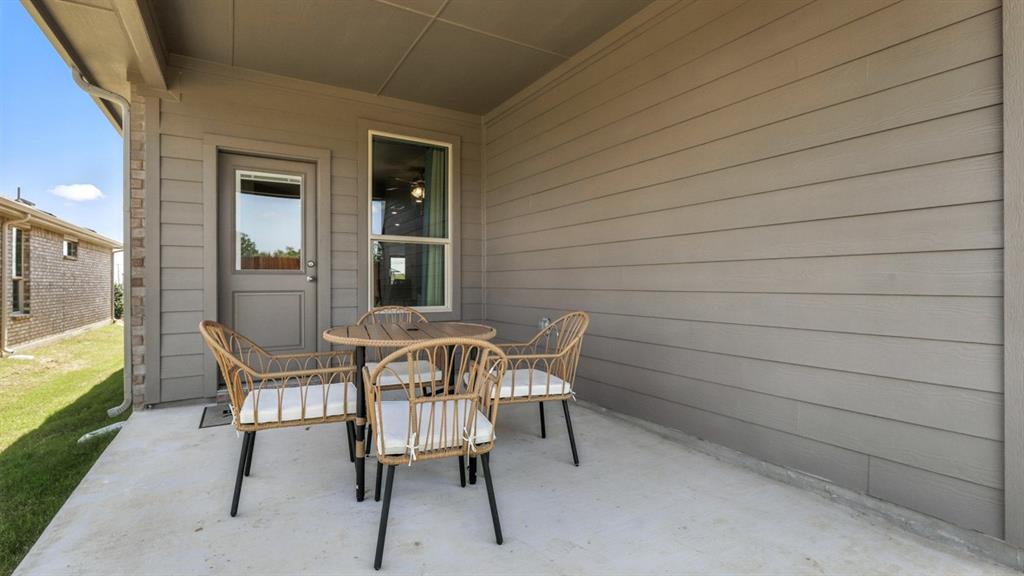 304 Perk Street Keene, TX 76059 - Photo 33 of 34 a view of a chairs and table in patio of a house