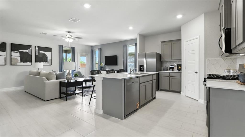 304 Perk Street Keene, TX 76059 - Photo 4 of 34 a large white open kitchen with cabinets a sink and a stove
