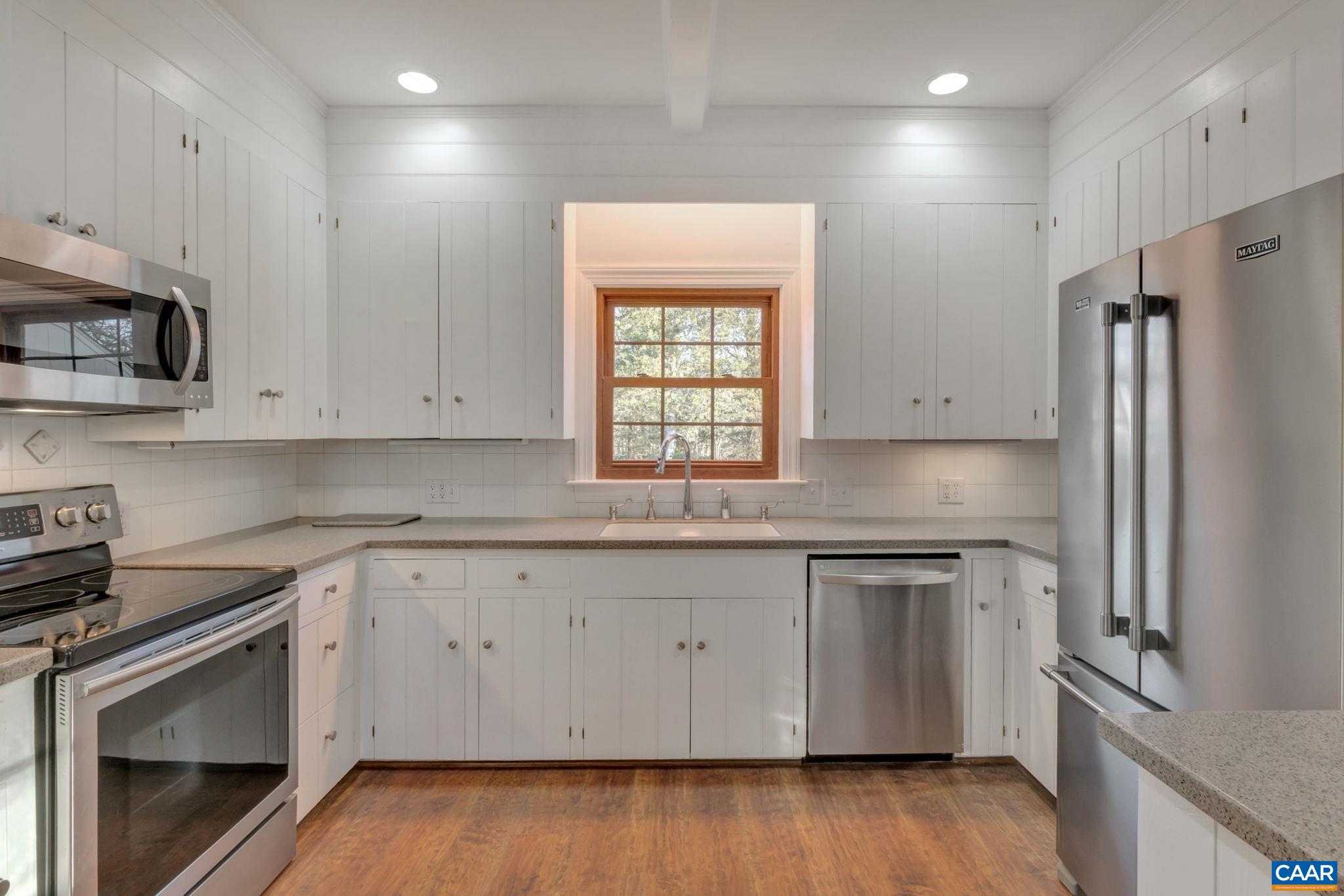 3432 Keswick Road Keswick, VA 22947 - Photo 7 of 60 a kitchen with granite countertop white cabinets white stainless steel appliances and wooden floors