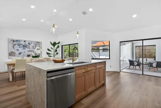 a view of a dining room with furniture a kitchen and chandelier