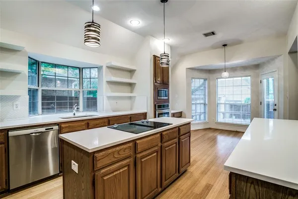 a kitchen that has a sink a stove and a wooden floor