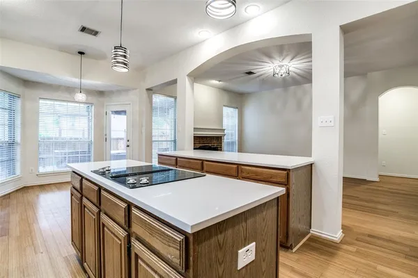 a kitchen that has a stove a sink a dining table and chairs in it