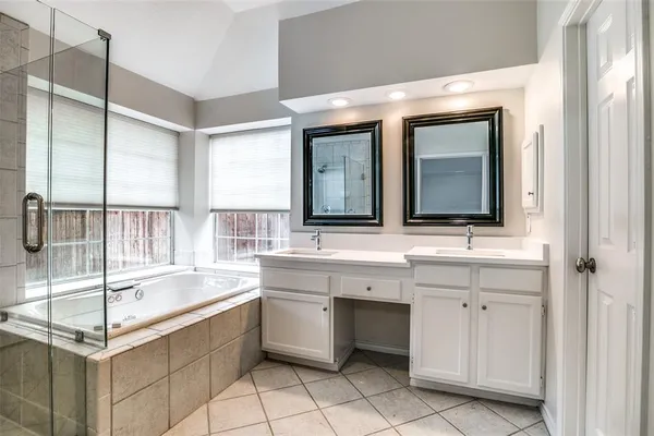 a large bathroom with a double vanity sink mirror and bathtub