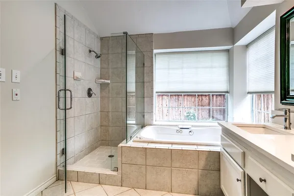 a bathroom with a tub sink and mirror