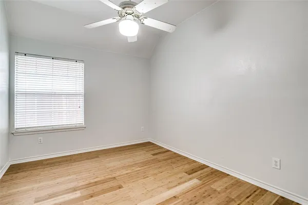 an empty room with a window and wooden floor