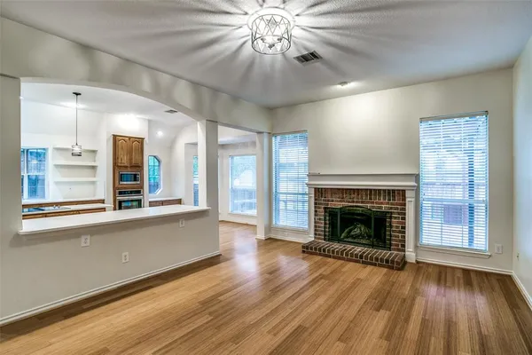 wooden floor fireplace and windows in an empty room