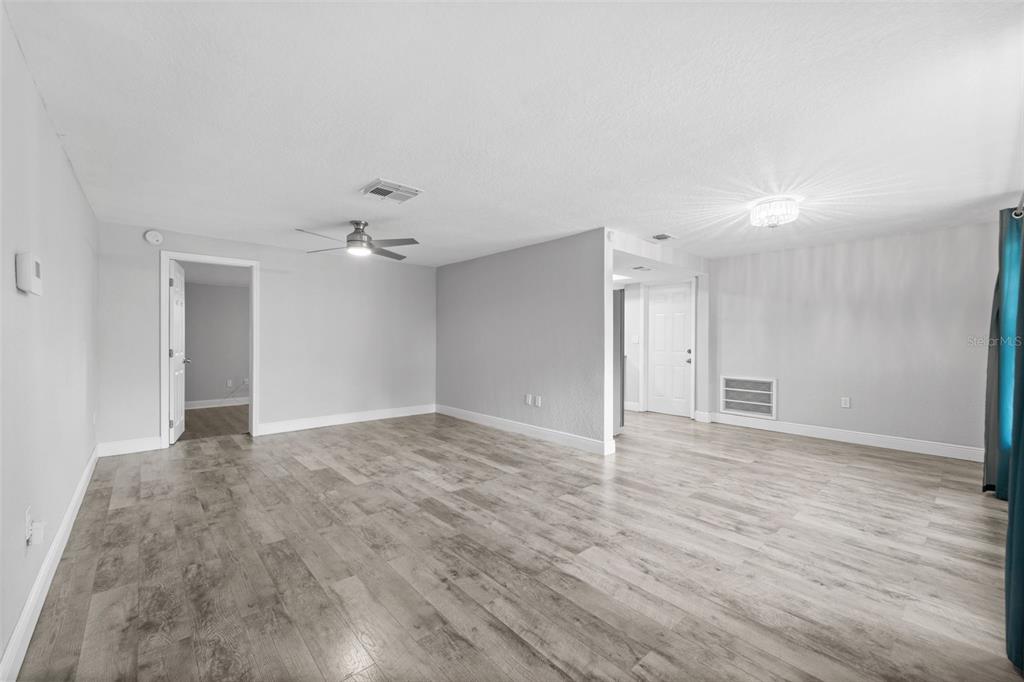 4238 Glissade Drive New Port Richey, FL 34652 - Photo 12 of 62 a view of an empty room with wooden floor and a ceiling fan