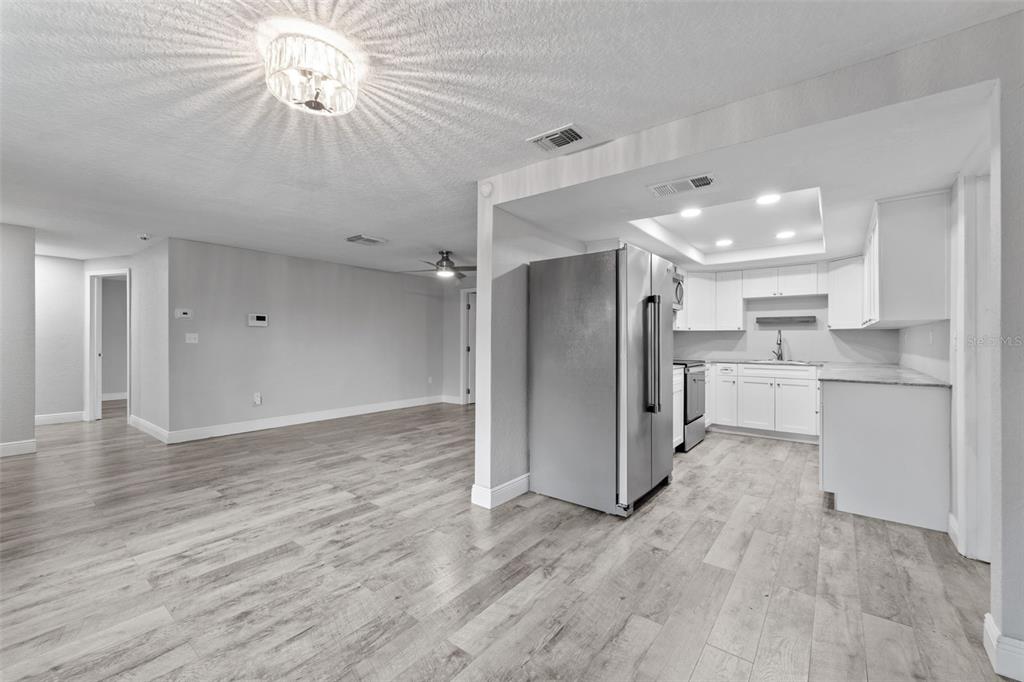 4238 Glissade Drive New Port Richey, FL 34652 - Photo 19 of 62 a view of a kitchen with a refrigerator and a chandelier fan