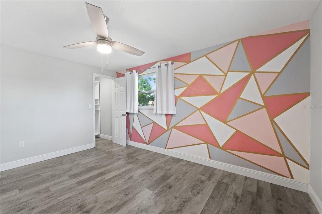 4238 Glissade Drive New Port Richey, FL 34652 - Photo 22 of 62 a room with wooden floor windows and ceiling fan
