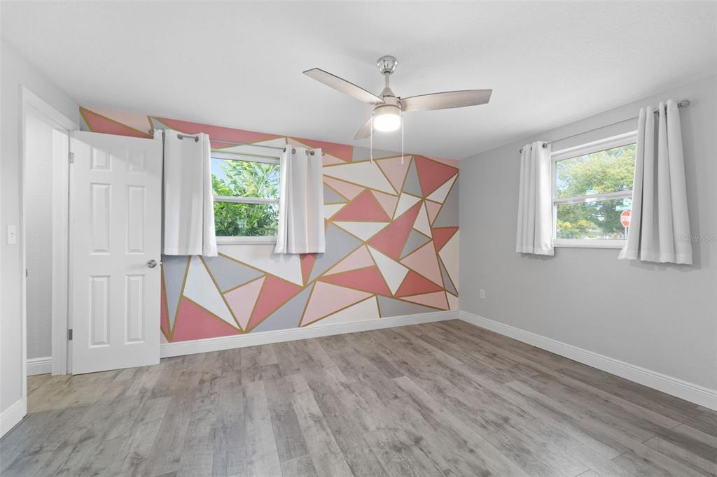 4238 Glissade Drive New Port Richey, FL 34652 - Photo 23 of 62 an room that has a ceiling fan and a wooden floor