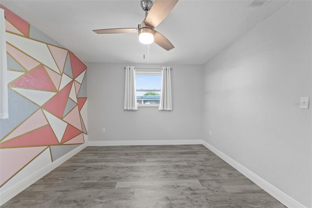 4238 Glissade Drive New Port Richey, FL 34652 - Photo 26 of 62 an empty room with wooden floor and windows