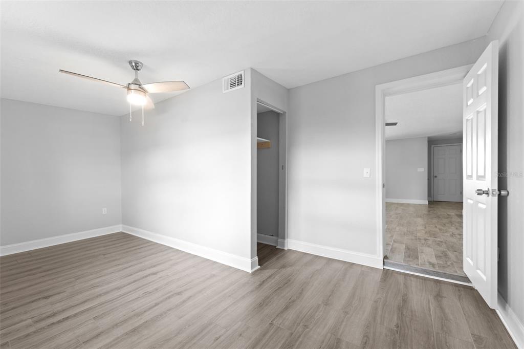 4238 Glissade Drive New Port Richey, FL 34652 - Photo 32 of 62 an empty room with wooden floor a ceiling fan and closet