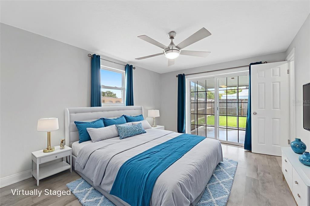 4238 Glissade Drive New Port Richey, FL 34652 - Photo 35 of 62 a bedroom with a large bed and a chandelier