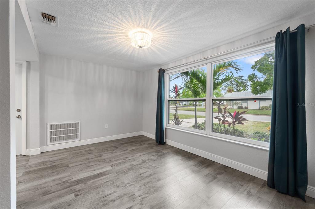 4238 Glissade Drive New Port Richey, FL 34652 - Photo 4 of 62 an empty room with wooden floor and windows