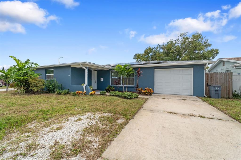 4238 Glissade Drive New Port Richey, FL 34652 - Photo 45 of 62 a front view of a house with a yard and garage