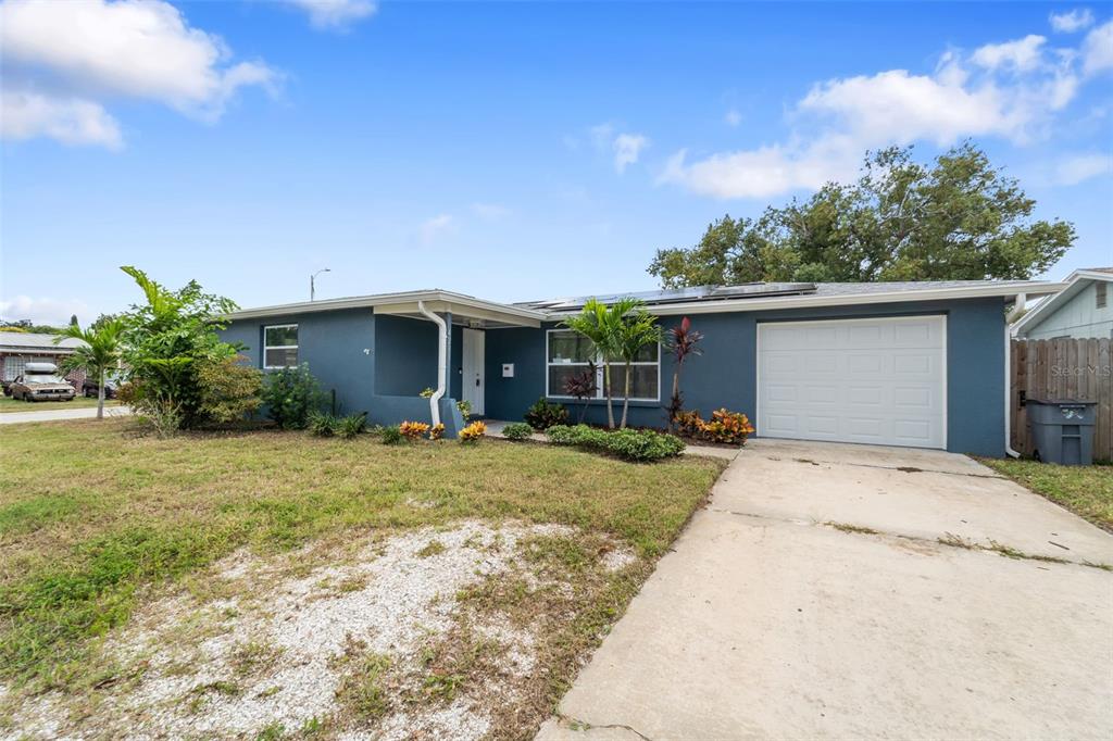 4238 Glissade Drive New Port Richey, FL 34652 - Photo 52 of 62 a front view of a house with a yard and potted plants
