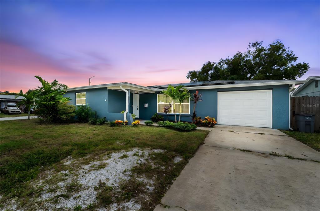 4238 Glissade Drive New Port Richey, FL 34652 - Photo 53 of 62 a front view of a house with a yard and garage