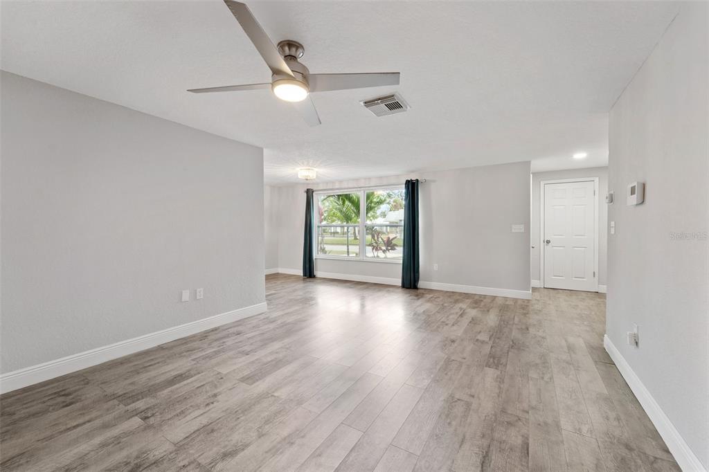 4238 Glissade Drive New Port Richey, FL 34652 - Photo 6 of 62 wooden floor in an empty room with a window