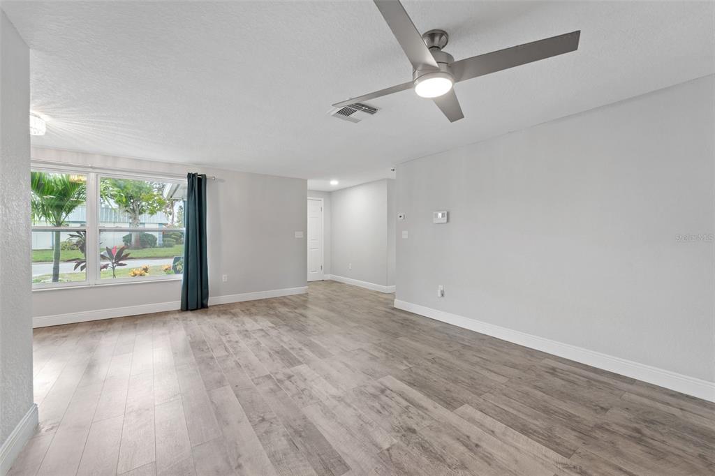4238 Glissade Drive New Port Richey, FL 34652 - Photo 7 of 62 an empty room with wooden floor and a window
