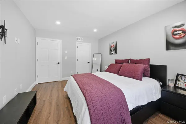 a spacious bedroom with a bed and a painting on the wall