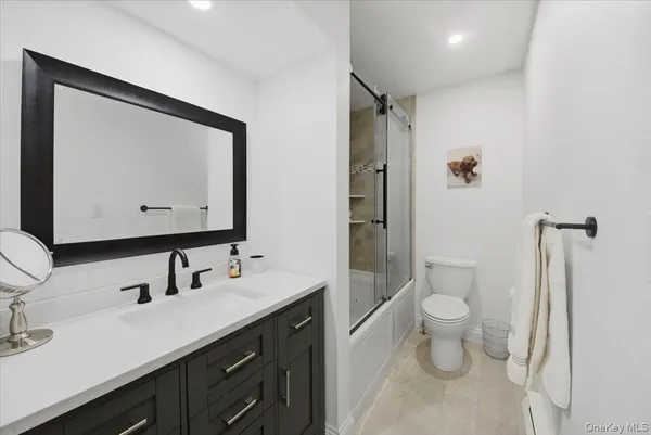 a bathroom with a toilet sink double vanity and mirror