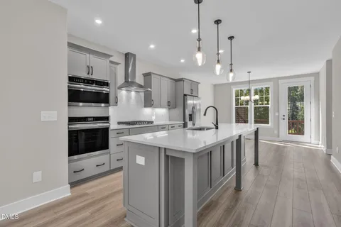 a kitchen with kitchen island granite countertop a sink cabinets and stainless steel appliances