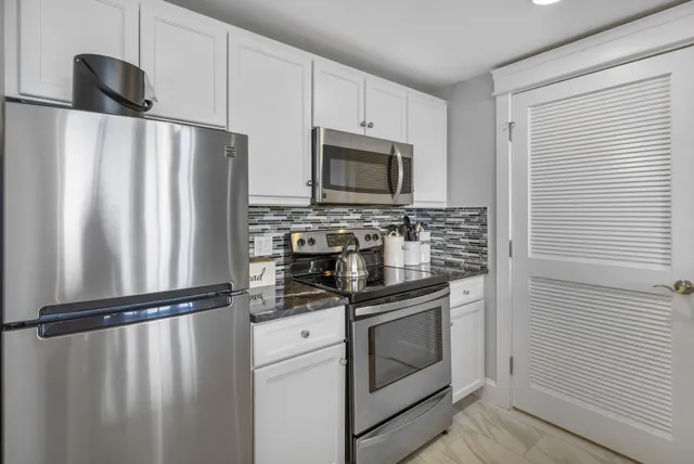 a kitchen with white cabinets stainless steel appliances and sink