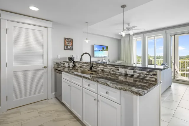a kitchen with granite countertop a sink cabinets and window