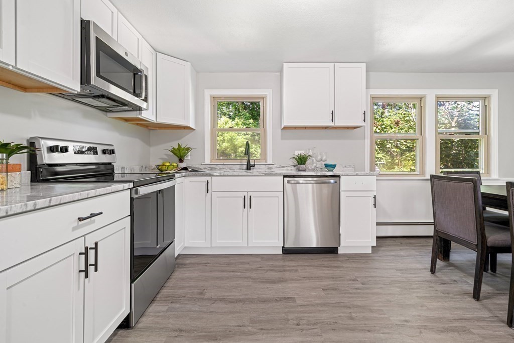 6 Coleman Road Groveland, MA 01834 - Photo 5 of 39 a kitchen with stainless steel appliances granite countertop a stove a sink dishwasher and a microwave oven with wooden floor