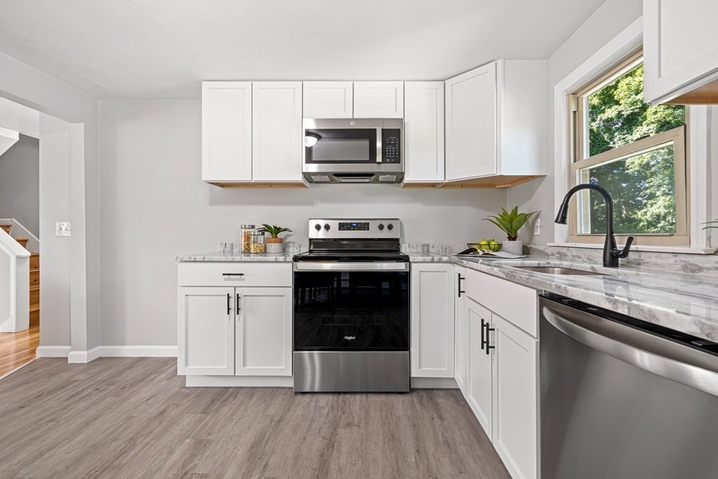 6 Coleman Road Groveland, MA 01834 - Photo 6 of 39 a kitchen with granite countertop a stove a sink and a microwave