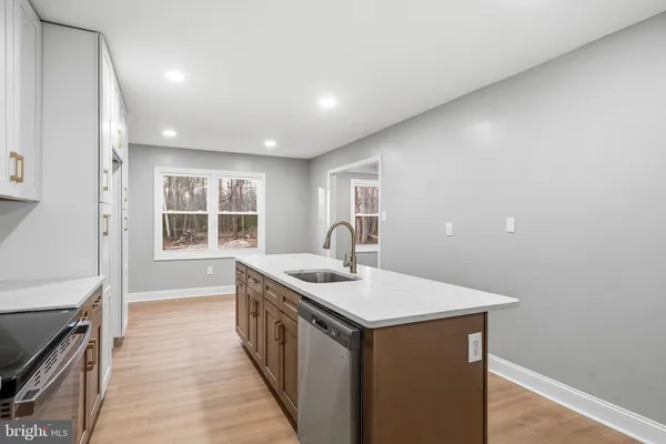 a kitchen with sink stove and cabinets
