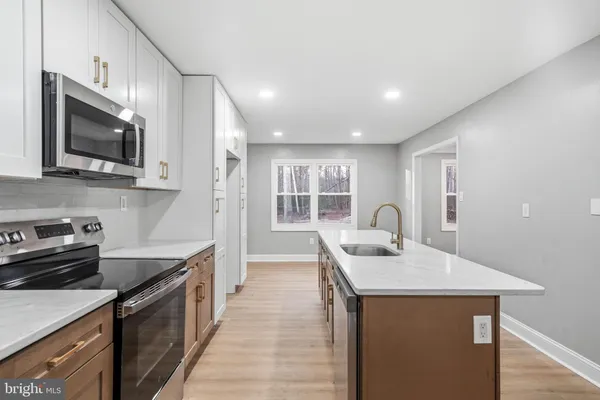 a kitchen with stainless steel appliances granite countertop a sink stove and microwave