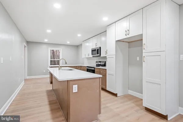 a kitchen with kitchen island a sink stove and refrigerator