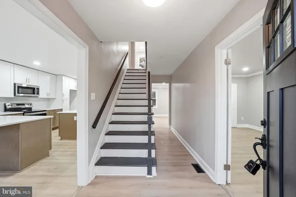 a view of a kitchen with wooden floor and electronic appliances