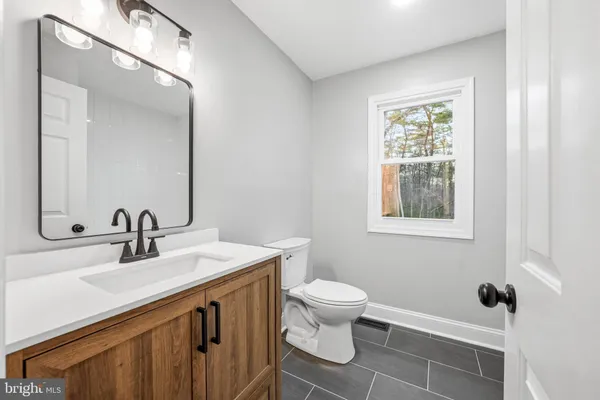 a bathroom with a sink toilet and mirror