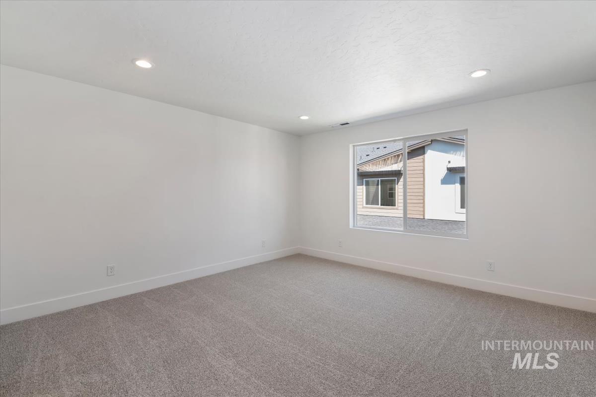 768 South Calhoun Lane Star, ID 83669 - Photo 22 of 36 Room featuring neutral gray carpet, recessed ceiling lighting, a large window, white walls, and white baseboards