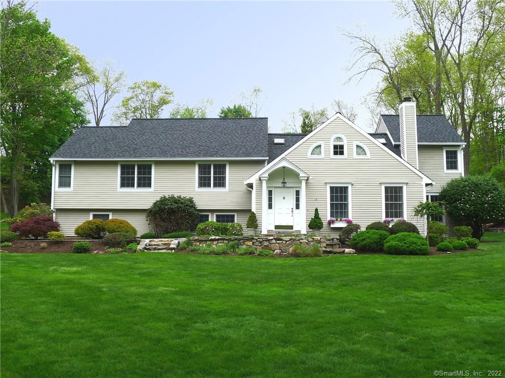 a front view of a house with a yard and trees
