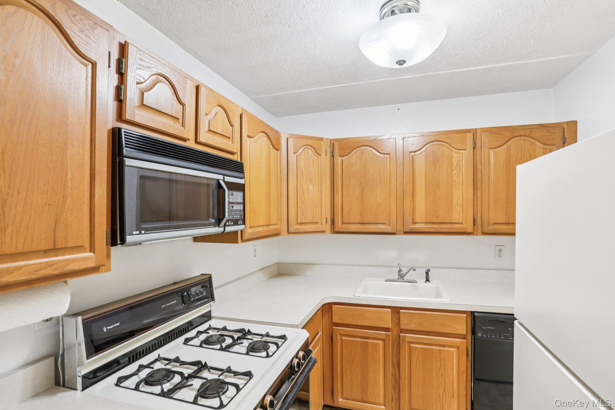 108 Sagamore Road, Unit 3E Tuckahoe, NY 10707 - Photo 15 of 30 a kitchen with stainless steel appliances a stove a sink and a microwave