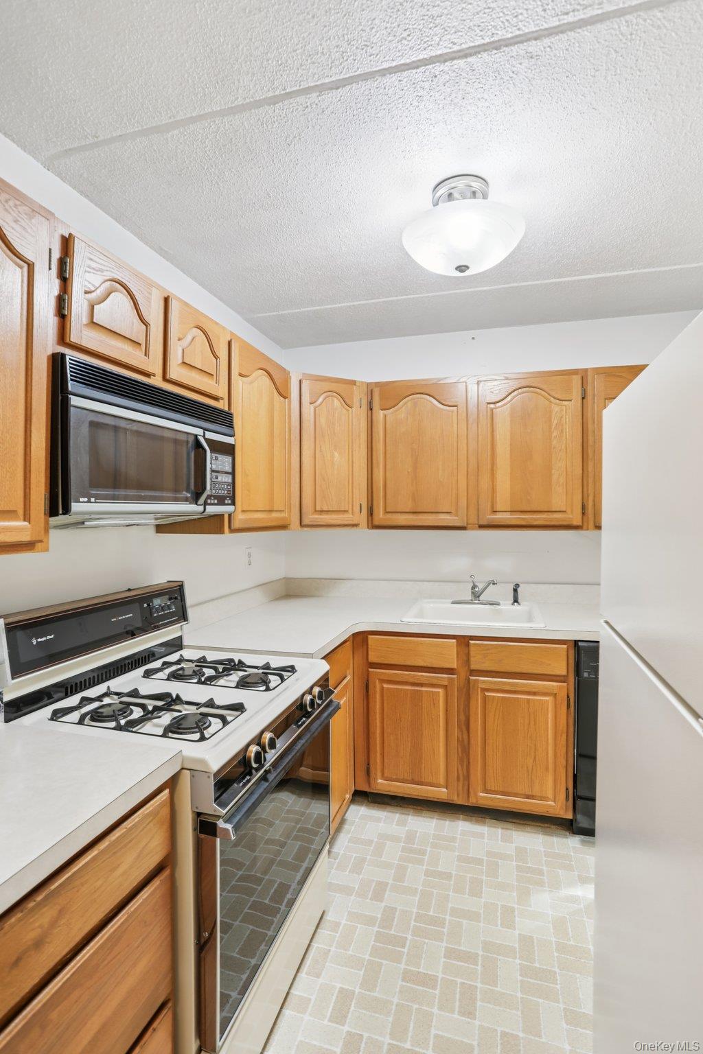 108 Sagamore Road, Unit 3E Tuckahoe, NY 10707 - Photo 16 of 30 a kitchen with stainless steel appliances granite countertop a stove a sink and a microwave