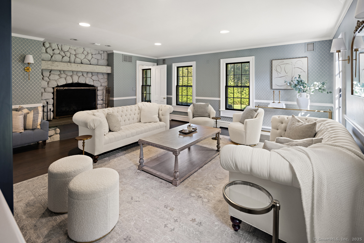 469 Brookside Road New Canaan, CT 06840 - Photo 18 of 40 a living room with furniture a fireplace and a table