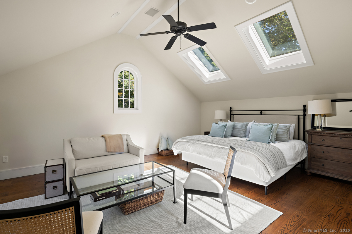 469 Brookside Road New Canaan, CT 06840 - Photo 26 of 40 a bedroom with a bed a couch and a chandelier