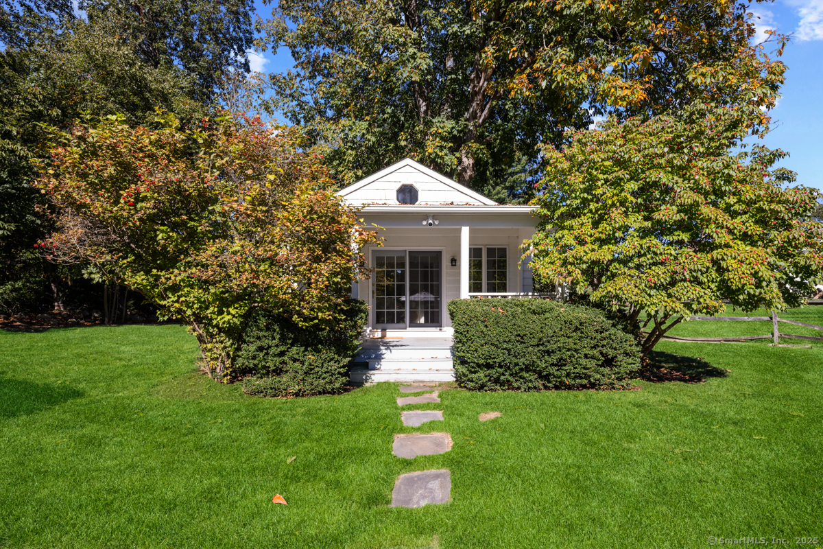 469 Brookside Road New Canaan, CT 06840 - Photo 28 of 40 a front view of a house with a garden