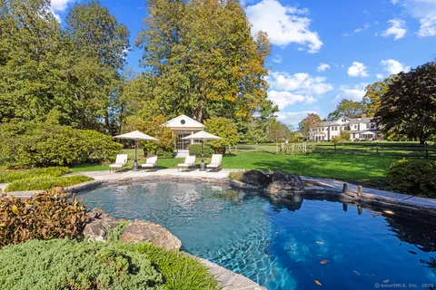a swimming pool with outdoor seating and yard