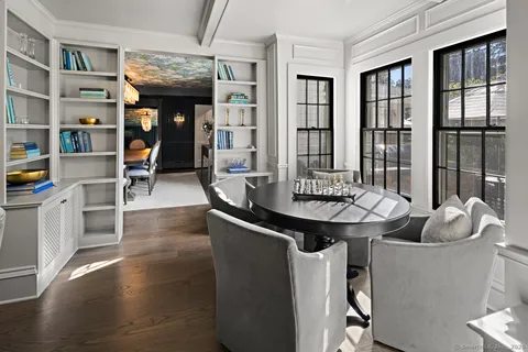 a dining room with furniture a chandelier and wooden floor