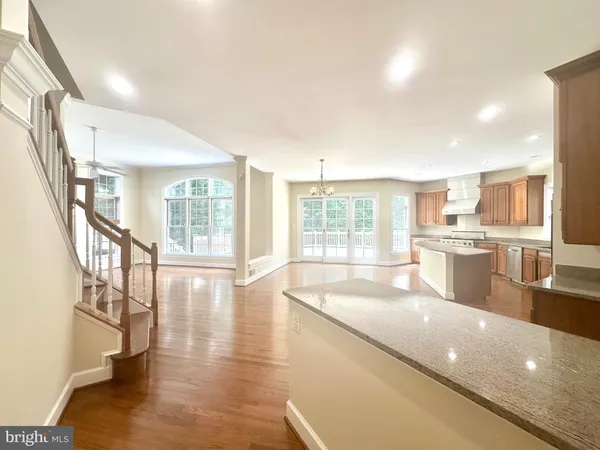 an empty room with wooden floor fireplace and windows