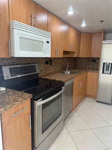 a kitchen with granite countertop a stove and a microwave